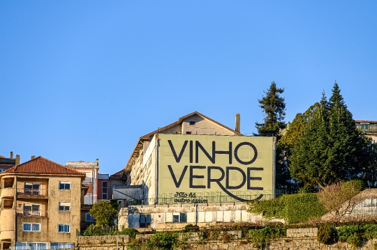 A building on the riverbank of the Douro River, with text on the