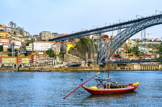 A rabelo boat on the Douro River, with the Luis I Bridge and the