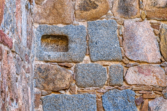 A rectangular carved hole in a stone block that is part of a med