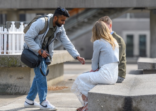 A wedding photographer working with a couple in Nathan Phillips