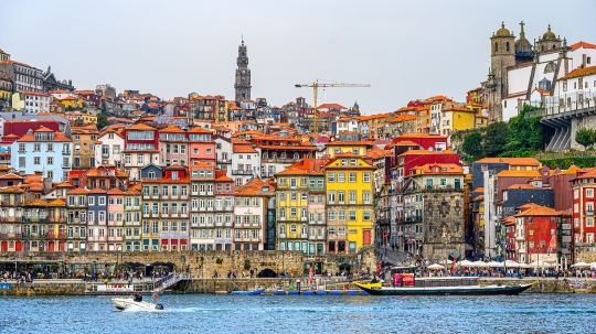 A yacht moving in the waters of the Douro River, with the famous