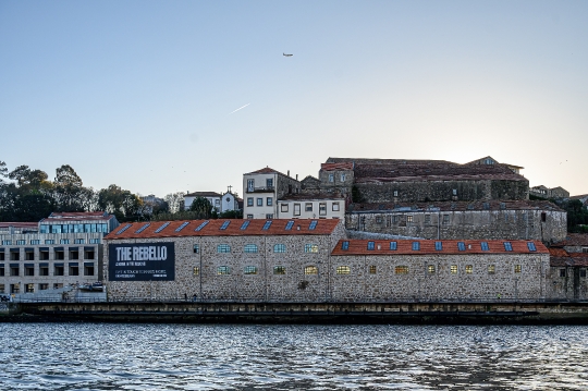 An ancient building on the riverbanks of the Douro River, with a