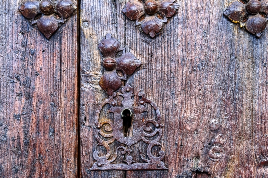 Ancient metallic keyhole and rivets on the surface of a medieval