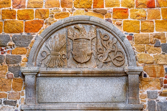 Ancient stone coat of arms on the exterior wall of the Parish of