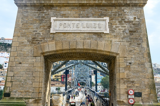 Arched stone wall with a sign on the Luis I Bridge. The old stru