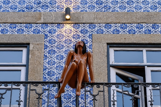 Art sculpture decorating the balcony of a house, with the facade