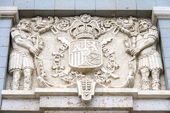 Bas-relief stone sculpture with a coat of arms in the facade of