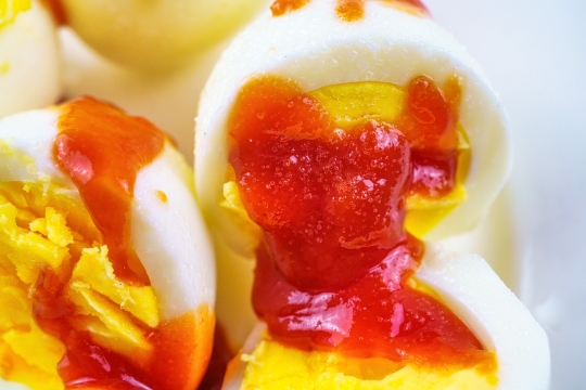 Boiled egg with ketchup and salt.