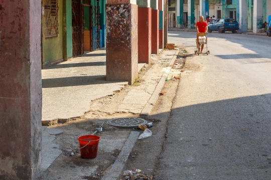 Bucket In Broken Sidewalk