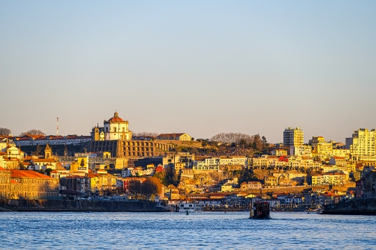 Cityscape by the waterfront district, featuring a vessel moving