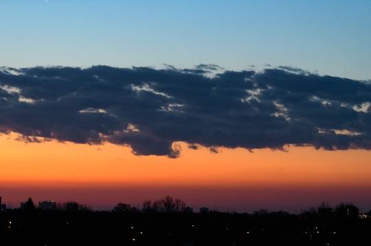 Cityscape in silhouette on a dramatic sunrise sky at dawn