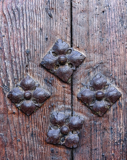 Close-up of medieval decorative rivets on the wooden surface of