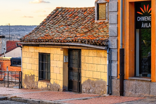 Facade of an ancient house building with a clay tile rooftop.