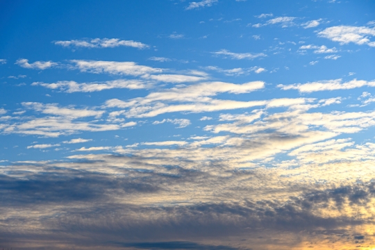 Gold colored light behind clouds of a morning sky