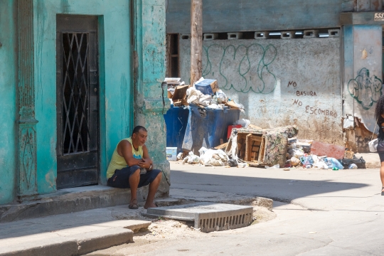 Havana, Cuba,  A Cuban man sits on the doorstep of a house