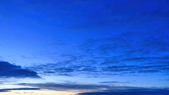 Intense blue dawn sky with clouds