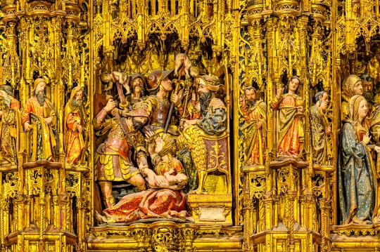 Intricacy of the main altar showing historic scenes and figures of religious saints.