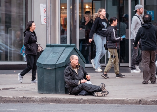 Man Sitting In Sidewalk