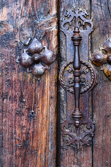 Medieval metallic door handle and decorative rivets on an ancien