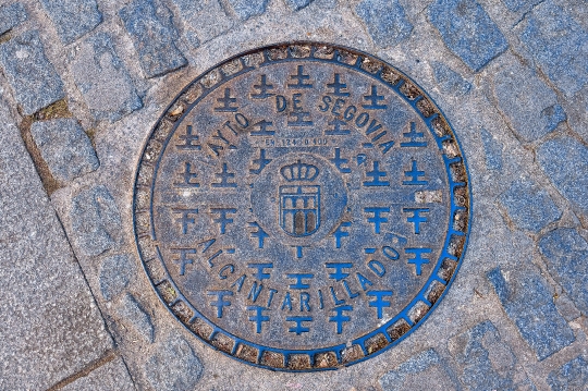 Metal manhole on cobblestone street