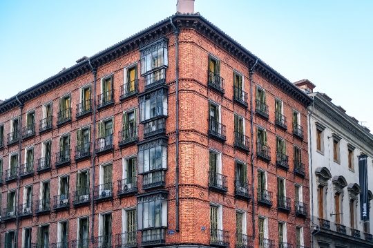 Old brick wall building featuring details of enclosed balconies.