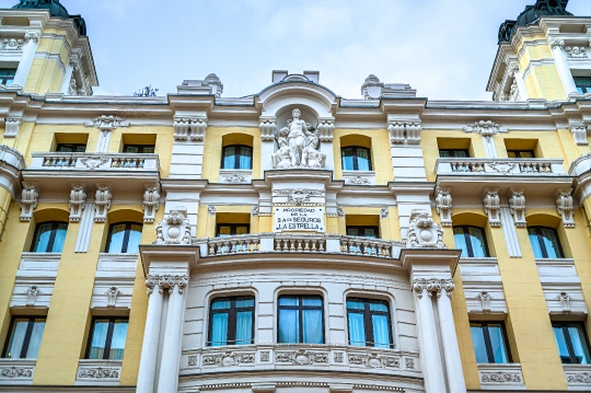 Old facade of a building in Gran Via. It has a sign reading that