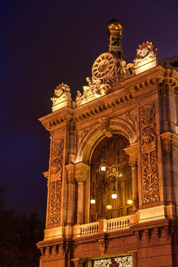 Part of the facade of the Banco de Espana building at night.