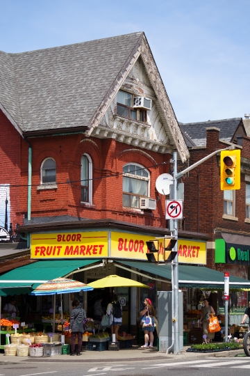 People walk by a Fruit Market