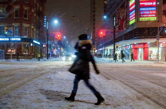 Person Crossing the Street During Snow Storm