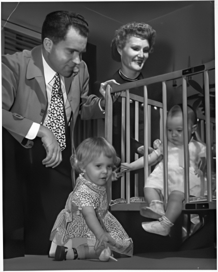 Richard Nixon and Pat Nixon observe their two young daughters.