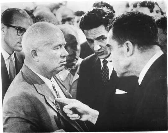 Richard Nixon points a finger towards Nikita Khrushchev to make