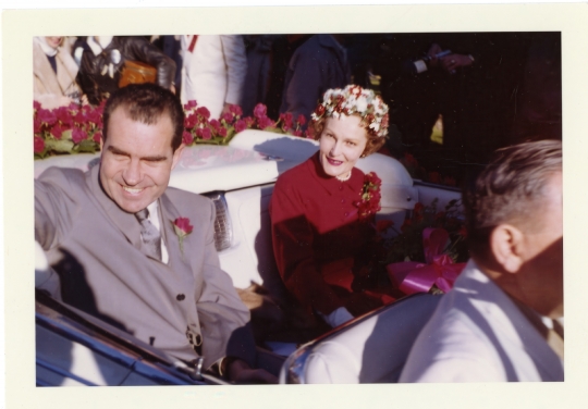 Richard Nixon rides in an automobile with Pat Nixon as Grand Mar