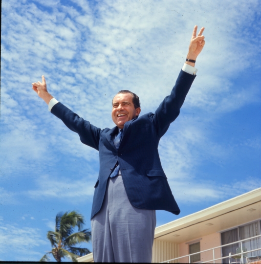 richard-nixon-gestures-a-double-victory-sign-with-his-hands-and-