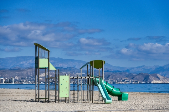 Slider and playground equipment in the sand of San Juan Beach, A