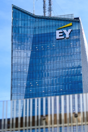 The EY (Ernst & Young) logo atop a tower in the financial distri