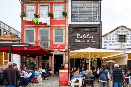 Tourists having lunch at patio restaurants by the Douro River in