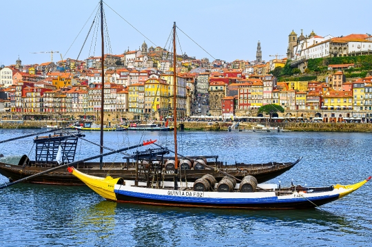 Two rabelo boats on the Douro River, with the famous cityscape o