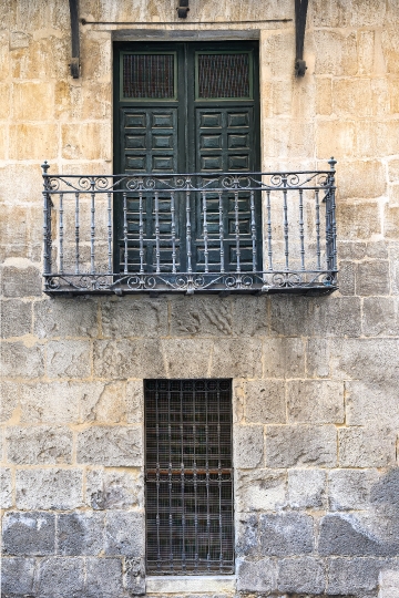 Windows and balcony in medieval stone wall. City Hall building,