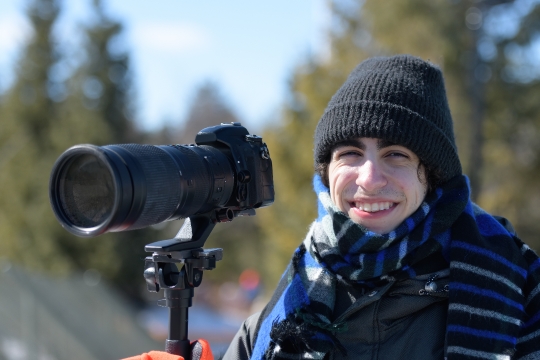 Young adult photographer with telephoto lens